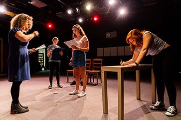 Students reading lines on a stage. Link to Gifts of Appreciated Securities
